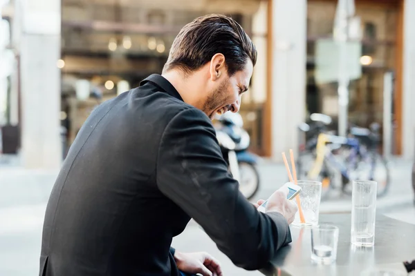 Man seated on bar in city — Stock Photo, Image