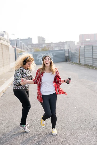 Frauen hören Musik mit Kopfhörern — Stockfoto