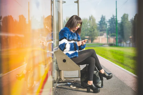 Žena sedící na autobusové zastávce — Stock fotografie