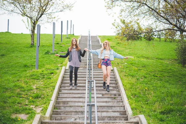Friends walking down stairs of city park — Stock Photo, Image