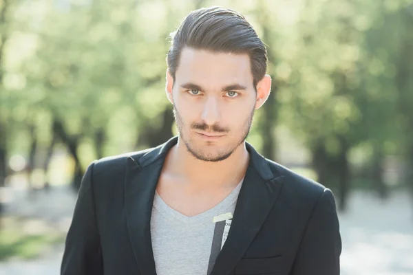 Handsome man posing in a park — Stock Photo, Image