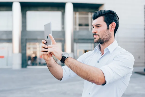 Hombre de negocios usando una tableta tomando fotos — Foto de Stock