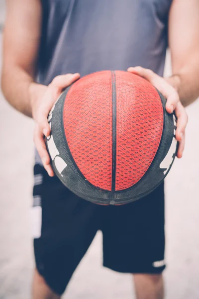 Homem esportivo segurando bola cesta — Fotografia de Stock