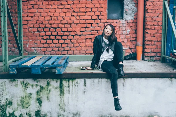 Asiatic woman leg crossed on small wall — Stock Photo, Image