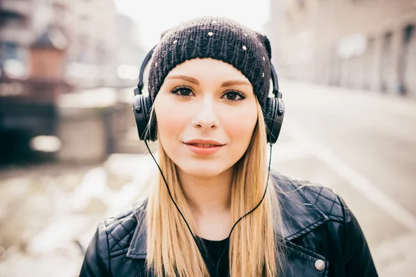 Kvinna med hörlurar lyssnar på musik — Stockfoto