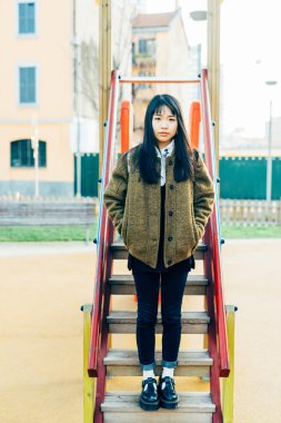 woman leaning on a slide in play ground