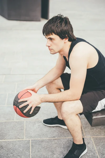 Homem esportivo segurando uma bola de cesta — Fotografia de Stock