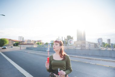 kırmızı saçlı kadın kabarcık sabun ile oynuyor