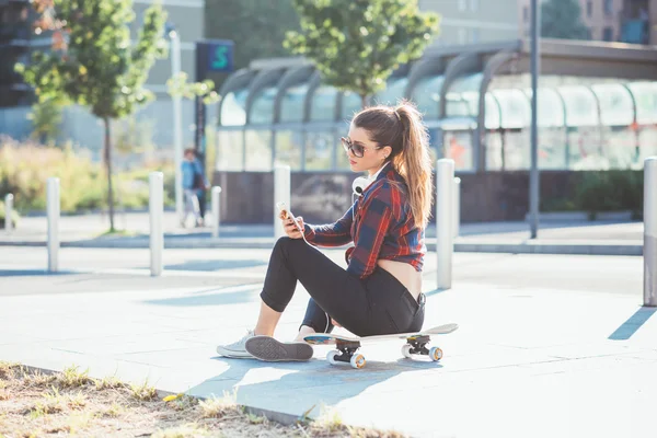 Frau sitzt auf Skateboard — Stockfoto