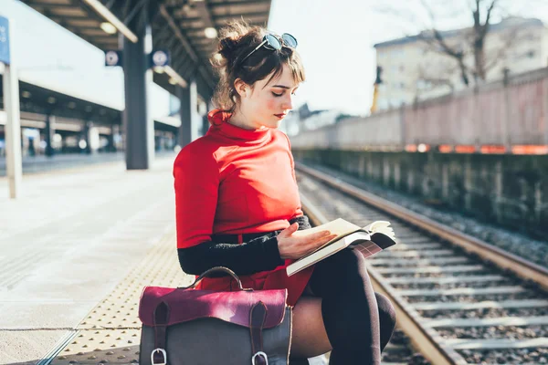 Vrouw zitten op platform in treinstation — Stockfoto