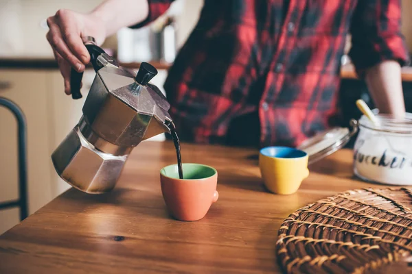 Mujer vertiendo café de una moka en una taza —  Fotos de Stock