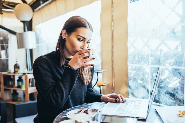 Woman sitting in bar with laptop — Stock Photo, Image