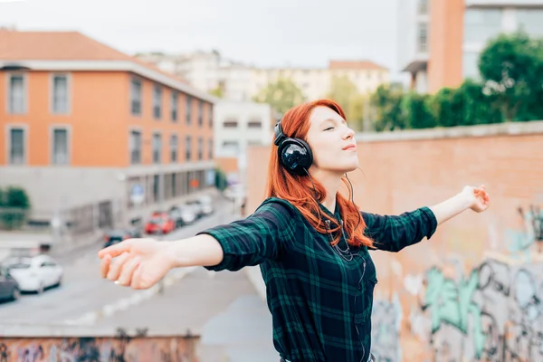 赤毛の女性の音楽を聴く — ストック写真