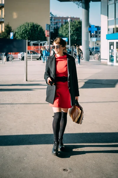 Rood geklede vrouw lopen in de stad — Stockfoto