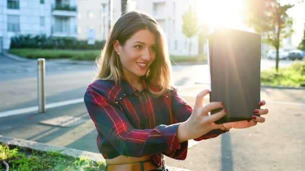 Mujer en ciudad sosteniendo la tableta tomando selfie — Vídeo de stock