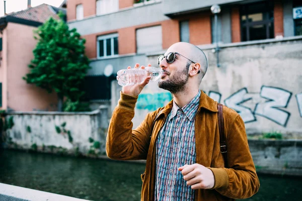 Gay man in city drinking water — Stock Photo, Image