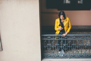 Smartphone kullanarak balkonda eğilerek kadın