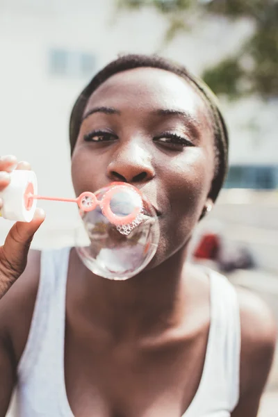 Negro mujer jugando con burbuja jabón — Foto de Stock