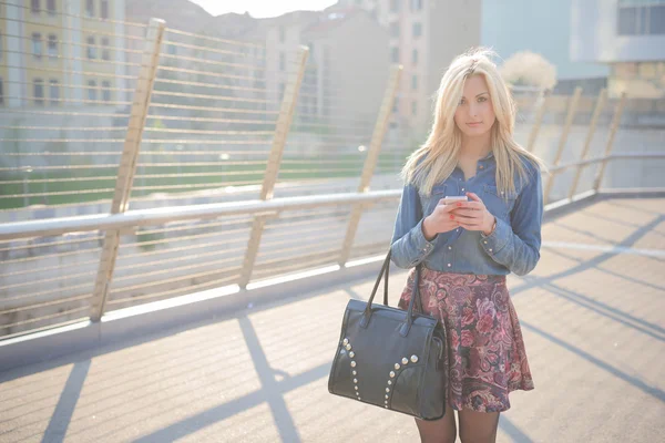 Jonge mooie blonde meisje in de stad — Stockfoto