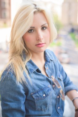 Kız şehirde bir pencere üzerinde Leaning poz