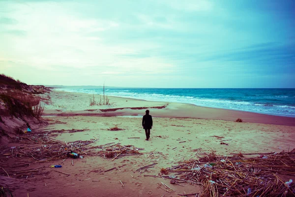 Homem andando ao longo da praia de areia no inverno — Fotografia de Stock