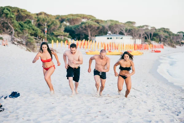 Amici multietnici in esecuzione sulla spiaggia — Foto Stock