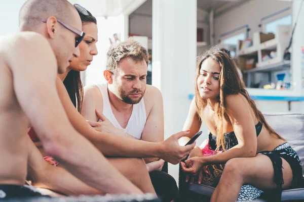 Vrienden zitten met smartphone — Stockfoto