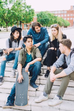 merdiven üzerinde oturan çok ırklı arkadaşlar