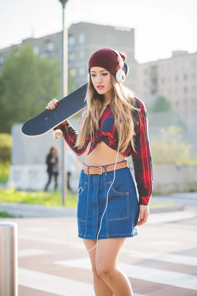 Mulher patinadora segurando skate — Fotografia de Stock
