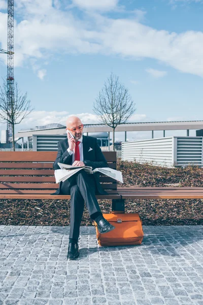 Uomo d'affari in panchina leggendo il giornale — Foto Stock