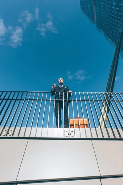 Businessman leaning on a handrail — Stockfoto