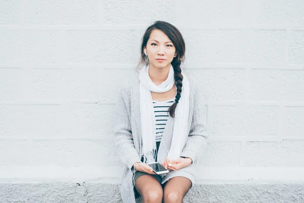 Woman leaning against white wall — Stock Photo, Image