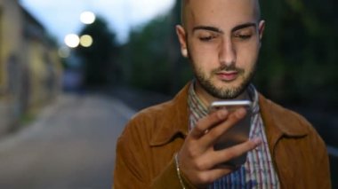 Şehir günbatımı erkekte smartphone kullanarak