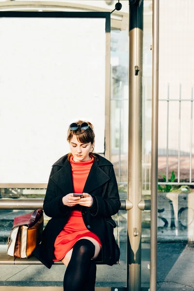 Hipster vrouw zitten bij bushalte — Stockfoto