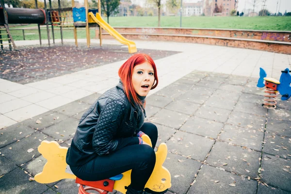 Vrouw spelen in een speeltuin in een park — Stockfoto