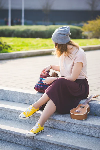Mujer hipster en la ciudad con ukelele — Foto de Stock