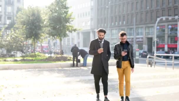 Ondernemers lopen in de stad met behulp van smartphones — Stockvideo