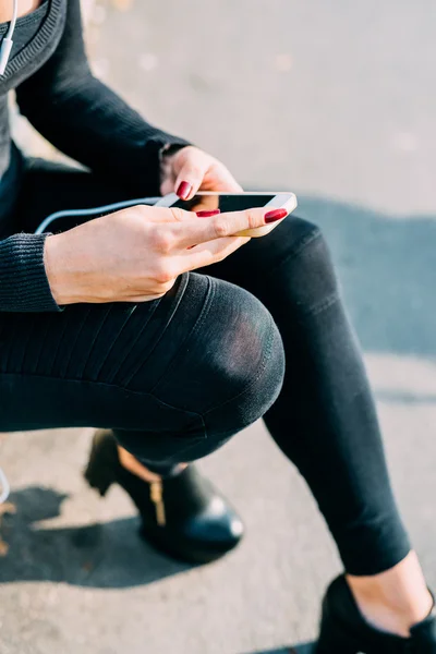 Mulher na calçada segurando smartphone — Fotografia de Stock