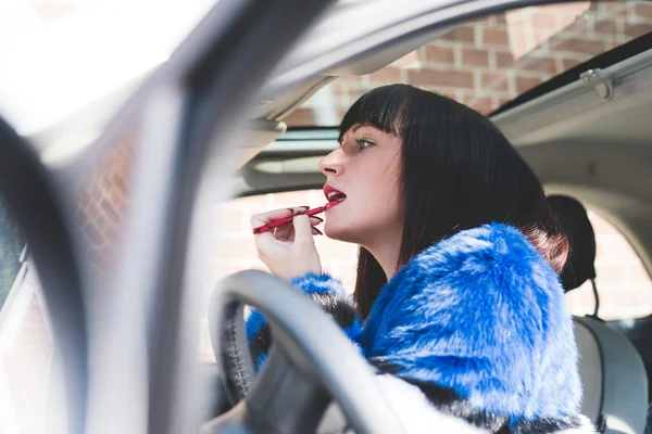 Mulher colocando em maquiagem em seu carro — Fotografia de Stock