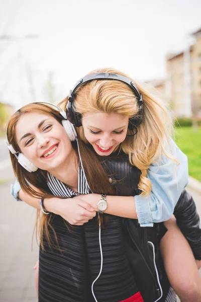 Tjejer som lyssnar på musik i city — Stockfoto