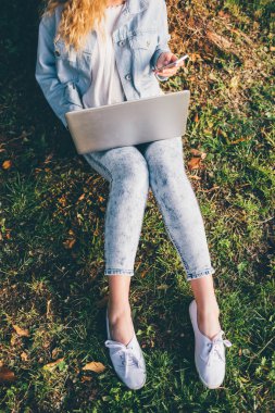 woman on the grass using notebook