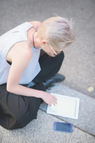 Блондинка итальянский дизайнер сидит на тротуаре — стоковое фото