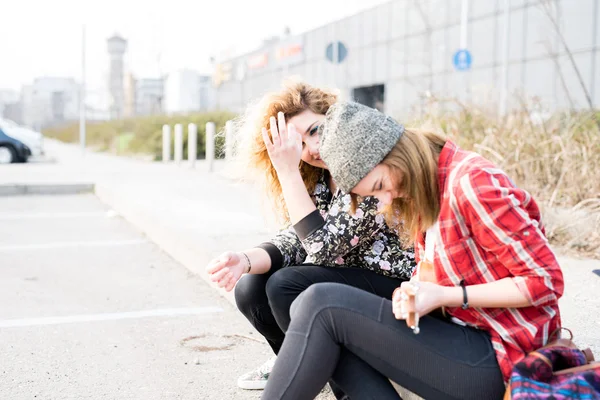 Γυναίκες κάθονται στο πεζοδρόμιο γελώντας — Φωτογραφία Αρχείου
