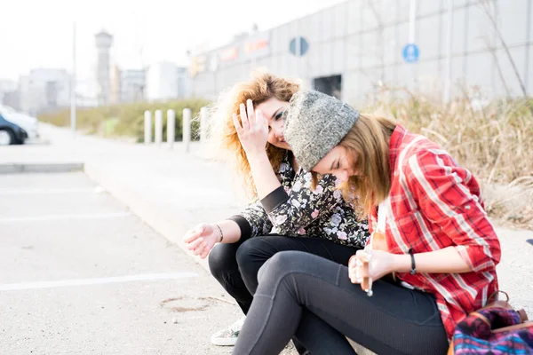 Vrouwen zitten op de stoep lachen — Stockfoto