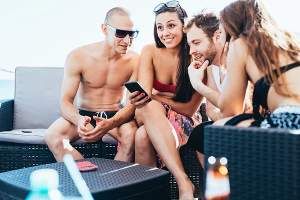 Multiethnische Freunde am Strand mit Smartphone — Stockfoto