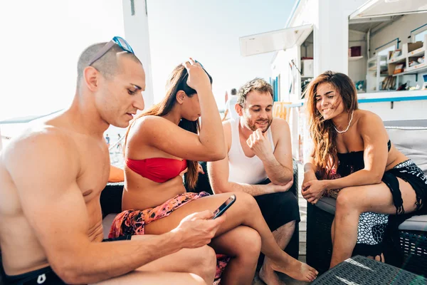 Multietniskt vänner på stranden med smartphone — Stockfoto