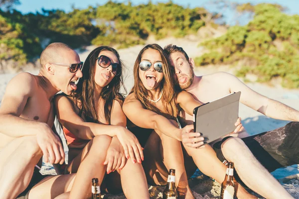 Vrienden op strand met behulp van Tablet PC — Stockfoto