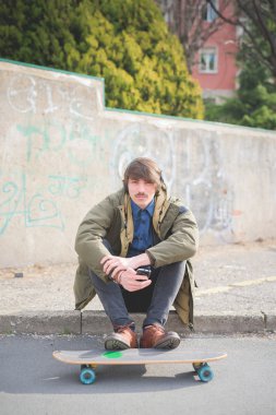 kaldırıma oturmuş bıyıklı adam patenci