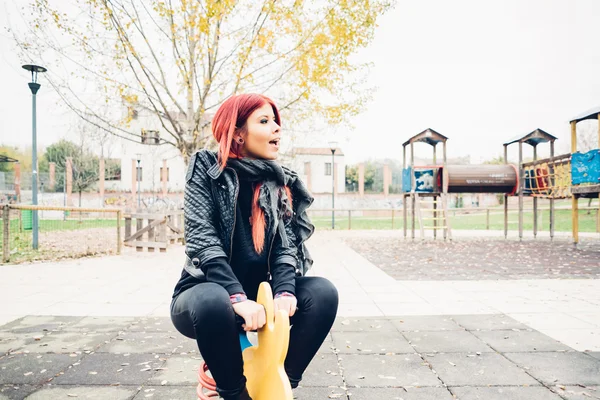 Oyun alanında oynamaya Kızıl saçlı kadın — Stok fotoğraf