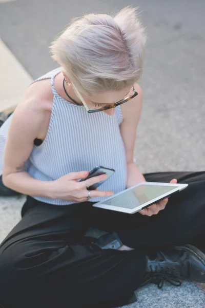 Designer sitting on sidewalk, using tablet — Stock Photo, Image